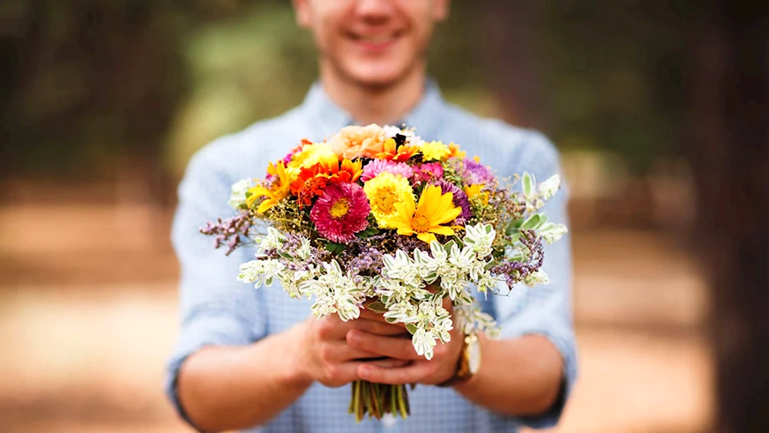 Букет полевых цветов в руках мужчины